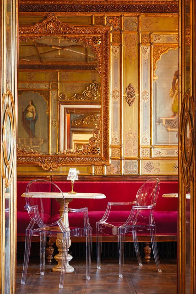 L'iconica sedia Louis Ghost creata da Philippe Starck nel 2002 per Kartell, in un ambiente in stile barocco, che ne esalta le caratteristiche estetiche. © Kartell