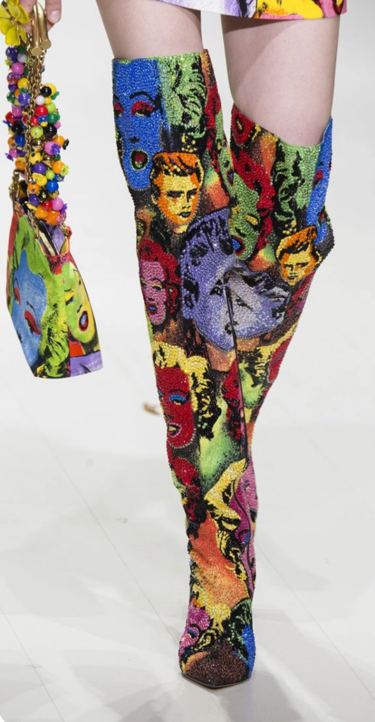 Stivali e borsa della collezione Versace primavera/estate 2018, che rende omaggio alla leggendaria collezione del 1991.