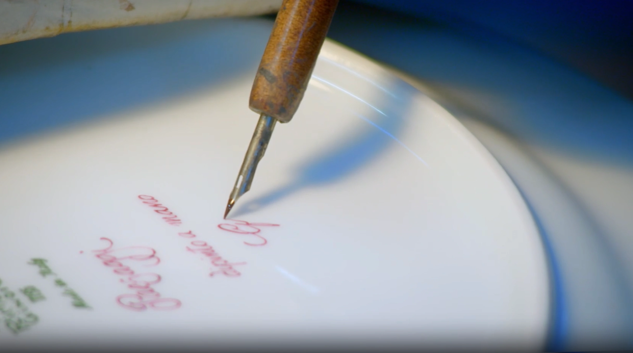 Il momento in cui viene apposta con un finissimo pennello la firma del marchio Ginori: la conclusione di un'operazione artistica di grande artigianato.