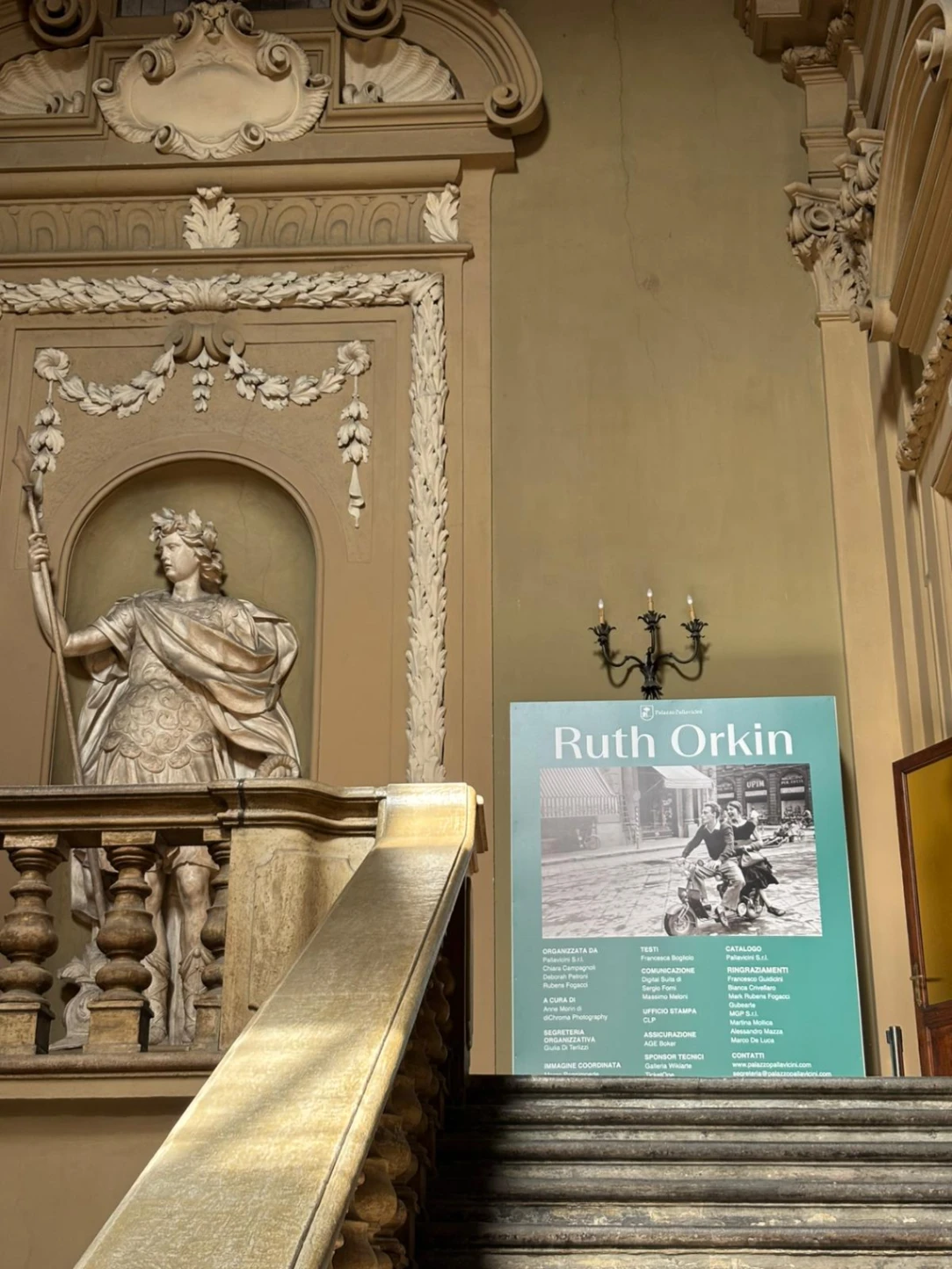 Lo scalone di Palazzo Pallavicini accoglie gli spettatori della mostra fotografica su Ruth Orkin.
