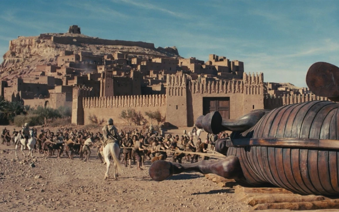 La scena del film di Christopher Nolan in cui il Cavallo di Troia viene introdotto all'interno delle mura della città dai Troiani inconsapevoli. Presentato come un dono votivo dedicato ad Atena, il gigantesco cavallo di legno nascondeva in realtà un inganno: al suo interno si celavano Ulisse e i guerrieri greci guidati da Agamennone, pronti a uscire durante la notte per aprire le porte della città e permettere la conquista di Troia.