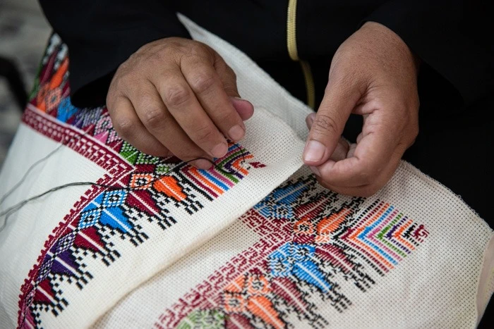 Spesso il ricamo palestinese viene realizzato con filo rosso su tessuti neri o chiari, ma può prevedere anche colori più accesi. © Nizar Halloun/TSM